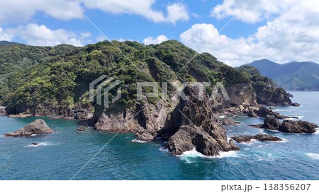 【空撮】荒々しい奇岩と緑の断崖絶壁が連なるダイナミックな海岸風景 138356207