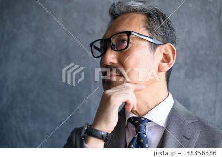 グレー背景で考える日本人男性 138356386