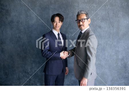 グレー背景で握手をする日本人男性 138356391