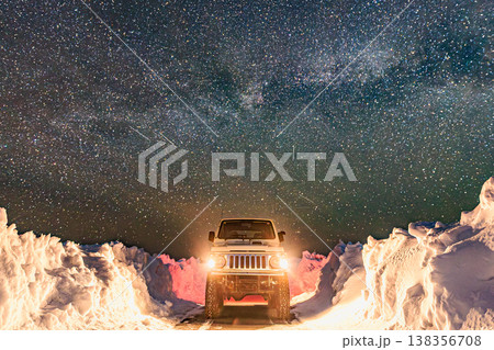 満天の星と天の川、雪道に佇むオフロード車の夜景 満天の星と天の川、雪道に佇むオフロード車の夜景 138356708