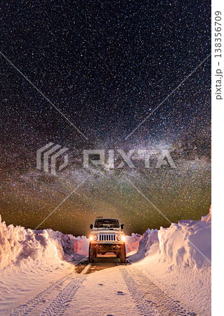 雪壁に囲まれた道と天の川、星空の下の四輪駆動車 雪壁に囲まれた道と天の川、星空の下の四輪駆動車 138356709