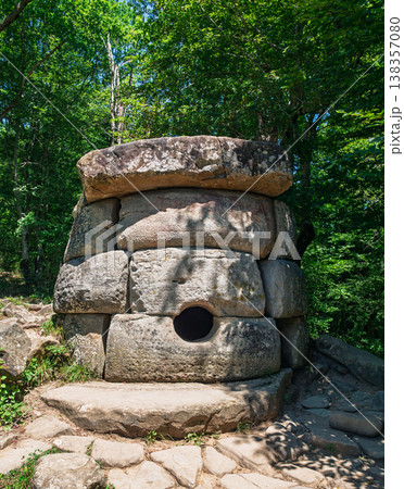 Prehistoric megalithic tomb made of massive stone blocks hidden deep within a vibrant summer forest 138357080
