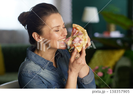 Woman Savoring Pizza with Eyes Closed Woman Savoring Pizza with Eyes Closed 138357905