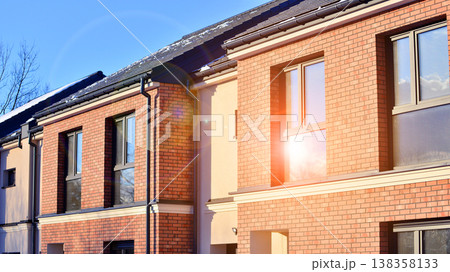 The real estate market in the suburbs. Terraced family homes in newly developed housing estate. New single family houses in a new development area. Residential homes with modern facade.  138358133