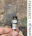 農機具の劣化したスパークプラグを手で持つ・整備写真 138358952