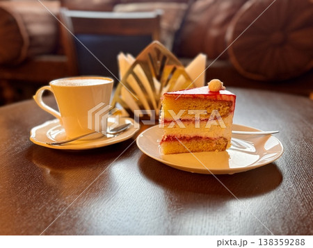Enjoying a delicious slice of cake paired wonderfully with a steaming cup of fresh coffee, ideal for a cozy break. Close-up. Enjoying a delicious slice of cake paired wonderfully with a steaming cup of fresh coffee, ideal for a cozy break. Close-up. 138359288
