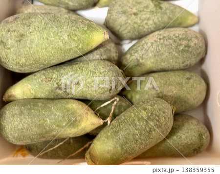 Green fresh chinese radish in a market counter for sale on sale in vegetable stand display at supermarket show organic food, vegetarian food, healthy food. Close-up. 138359355
