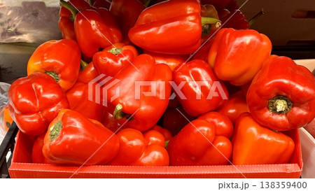 Vibrant red bell peppers are abundant in a market basket, showcasing their freshness and vivid color. Close-up. Vibrant red bell peppers are abundant in a market basket, showcasing their freshness and vivid color. Close-up. 138359400