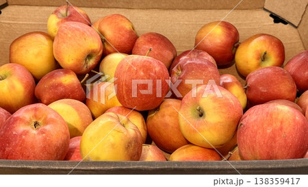 A vibrant and colorful display of fresh, crisp red apples organized neatly in a bustling market settings. Close-up. A vibrant and colorful display of fresh, crisp red apples organized neatly in a bustling market settings. Close-up. 138359417