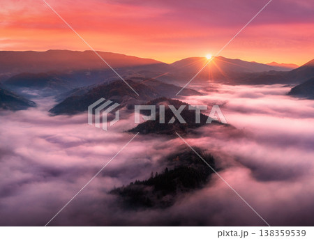 Aerial view of mountains in low clouds at sunrise in autumn Aerial view of mountains in low clouds at sunrise in autumn 138359539
