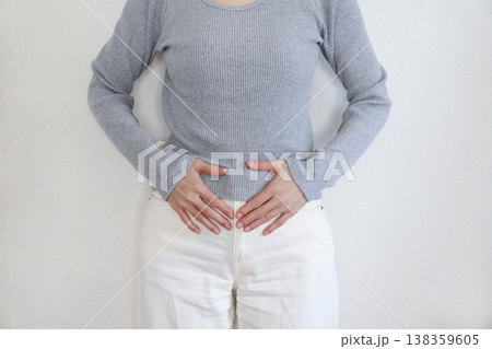 タイトル 腹痛で腹部を押さえる女性 138359605