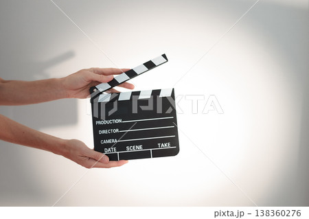 Hands holding clapperboard, signaling action on film set for movie a scene production, directing Hands holding clapperboard, signaling action on film set for movie a scene production, directing 138360276
