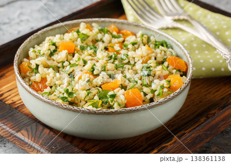 Vegetarian bulgur salad with parsley and dried apricots close-up in a bowl. Horizontal 138361138