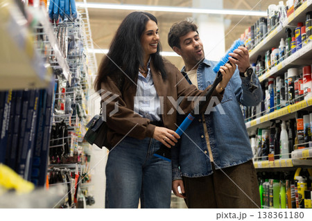 Young couple looking at a car cleaning brush in an automotive retail store 138361180