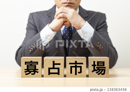 「寡占市場」と書かれたブロックとビジネスマン 「寡占市場」と書かれたブロックとビジネスマン 138363436