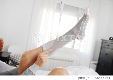 a man checks a compression sock on his leg a man checks a compression sock on his leg 138363764