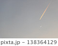 夕空に伸びる飛行機雲と三日月 138364129
