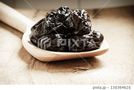 dried plums prunes on wooden spoon dried plums prunes on wooden spoon 138364628
