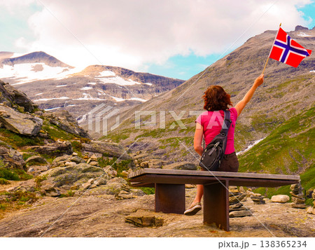 Tourist with norwegian flag on Trollstigen area Tourist with norwegian flag on Trollstigen area 138365234