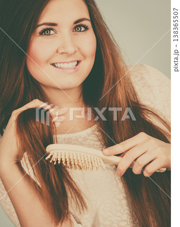 Happy woman brushing her hair Happy woman brushing her hair 138365507