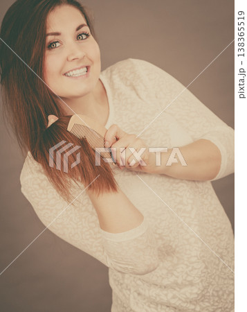 Happy woman brushing her hair Happy woman brushing her hair 138365519
