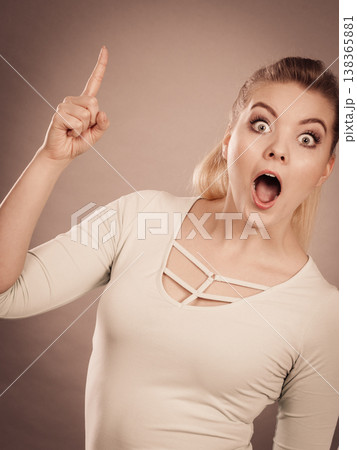 Happy woman pointing up with one finger. Happy woman pointing up with one finger. 138365881