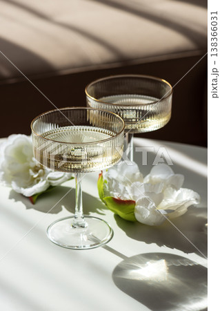 Champagne Glasses with Flowers under Sunlight. Elegant Celebration Scene 138366031