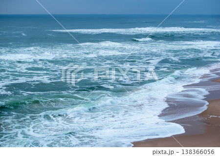Coastal Cliff and Crashing Ocean Waves on Beach 138366056