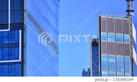 The glass exterior wall of the skyscrapers in the financial center. Tall glass skyscrapers in the city center. The glass exterior wall of the skyscrapers in the financial center. Tall glass skyscrapers in the city center. 138366164