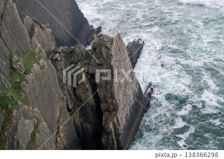 Dramatic Coastal Beach Scene with Waves and Cliff 138366298