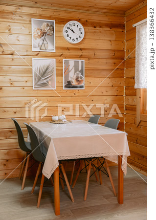 Dining area in wooden cabin with table, chairs and wall decor Dining area in wooden cabin with table, chairs and wall decor 138366432