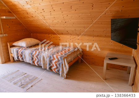 Cozy attic bedroom with wooden walls, bed and tv in hostel Cozy attic bedroom with wooden walls, bed and tv in hostel 138366433