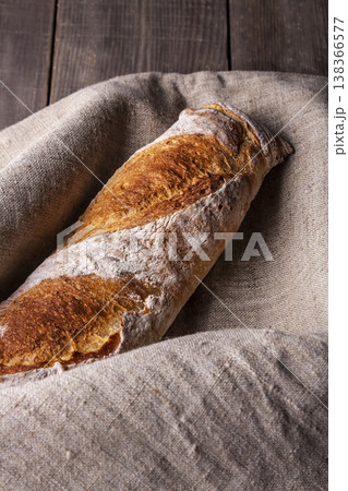Freshly baked french baguette in on wooden background. High quality photo Freshly baked french baguette in on wooden background. High quality photo 138366577