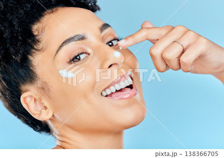 Beauty skincare, portrait and happy woman with cream application of dermatology product for pimple, acne or spots prevention. Face makeup, studio cosmetics or aesthetic person on blue background 138366705