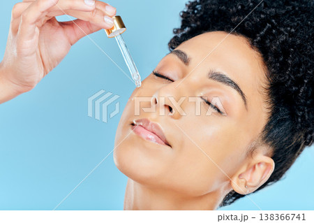 Beauty, relax face and woman with serum application for skin hydration, anti aging and collagen essential oil liquid for skincare. Retinol dropper, hyaluronic acid or studio person on blue background Beauty, relax face and woman with serum application for skin hydration, anti aging and collagen essential oil liquid for skincare. Retinol dropper, hyaluronic acid or studio person on blue background 138366741