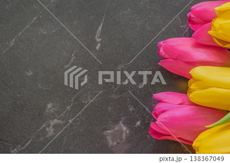 Luxury dark moody composition of yellow and pink tulips on black marble. Vibrant spring flowers with soft lighting and ample copy space for premium branding 138367049