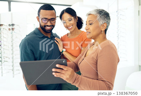 Tablet, optometry and woman with patients in a store for spectacle frame browsing on the internet. Consultation, digital technology and optometrist with people for choosing glasses in optical clinic. 138367050