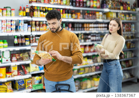 Young couple chooses beans in store Young couple chooses beans in store 138367367