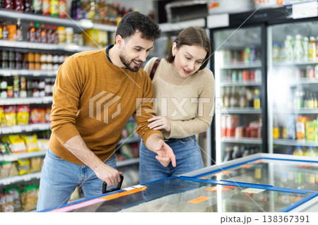 Young couple choosing frozen food in grocery store Young couple choosing frozen food in grocery store 138367391