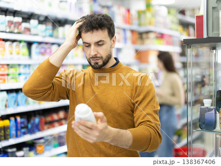 Man spends time in store, looking for goods and select care product 138367406