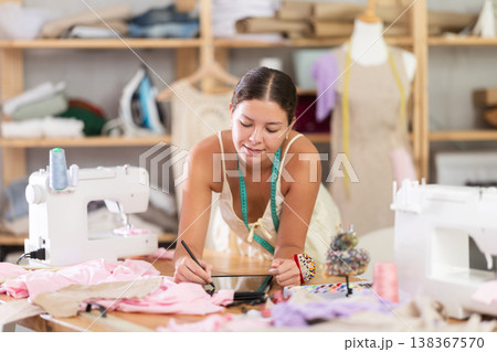 Young female dressmaker drawing on tablet in...の写真素材 [138367570] - PIXTA