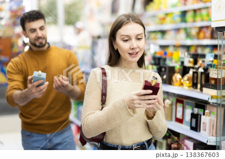 Couple choosing bottle of perfume in perfume shop Couple choosing bottle of perfume in perfume shop 138367603