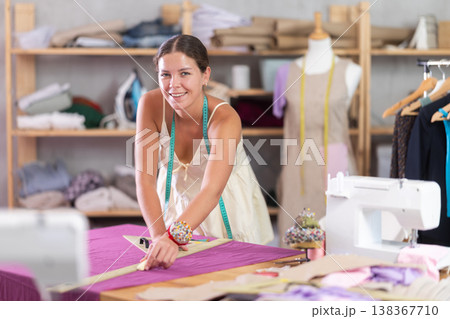 Using ruler, woman tailor draws dress diagram scheme on fabric Using ruler, woman tailor draws dress diagram scheme on fabric 138367710