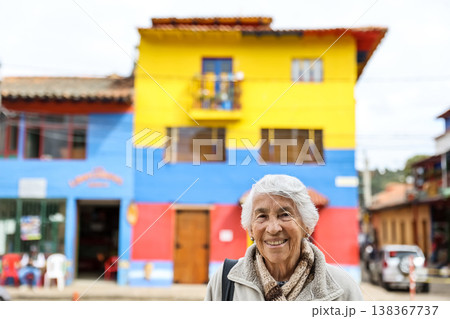 Happy senior lifestyle concept. Senior woman at the central square of the beautiful small town of Raquira. The city of pots in Colombia. 138367737