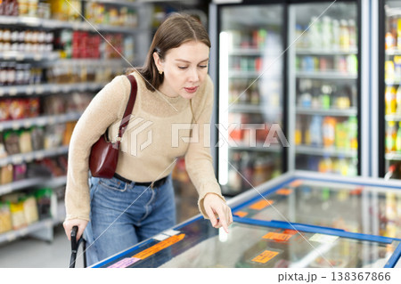 Young woman choosing frozen food in grocery store Young woman choosing frozen food in grocery store 138367866