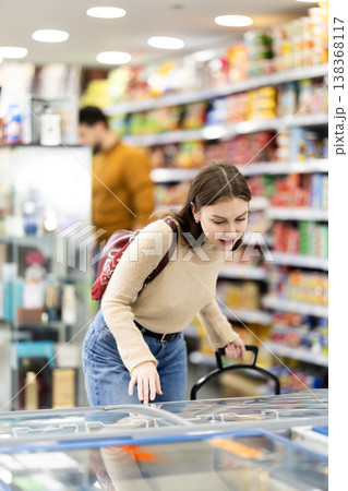 Young woman choosing frozen food in grocery store 138368117