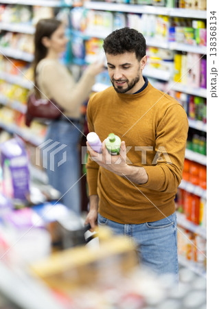 Male shopper is shopping in a supermarket, buying body care products 138368134