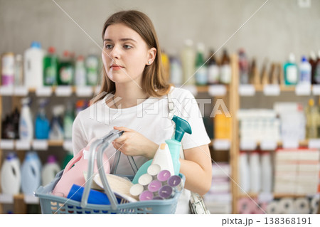 Young woman chooses household chemicals in store 138368191