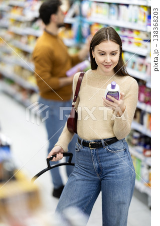 Woman spends time in store, looking for goods and select care product Woman spends time in store, looking for goods and select care product 138368203