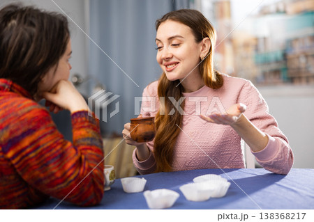 Two female friends drinking tea and talking at home 138368217